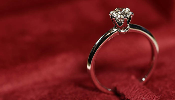 diamond wedding ring on red background. Object social hold as symbolic element of eternal love and commitment. so expensive concept.