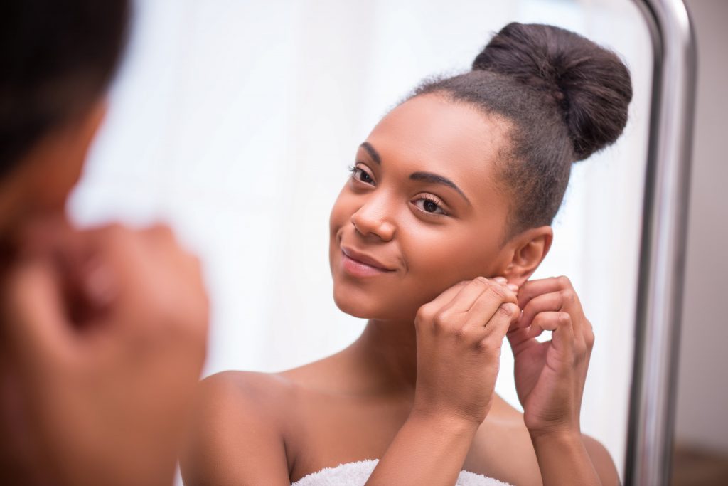 woman taking off earrings